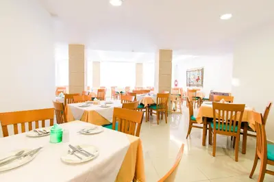 a dining room with white tables and chairs at Hotel Riviera in Rhodes Town