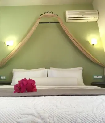a bedroom with a white bed with a pink flower on it at Fiore di Flora in Archangelos