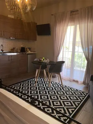 a living room with a table and a kitchen at Fiore di Flora in Archangelos