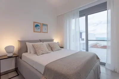 a bedroom with a large bed and a large window at Luxury Sunrise White Villa in Líndos