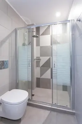 a bathroom with a toilet and a glass shower at Luxury Sunrise White Villa in Líndos