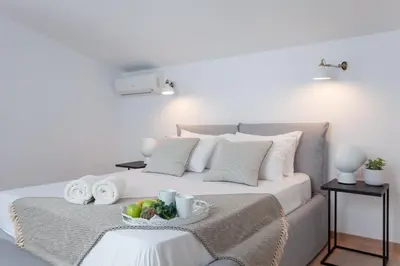 a bedroom with a bed with a bowl of fruit on it at Luxury Sunrise White Villa in Líndos
