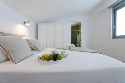 a bowl of fruit on a white bed at Luxury Sunrise White Villa in Líndos