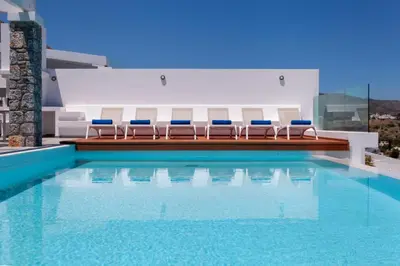 a swimming pool with blue chairs and a pool at Luxury Sunrise White Villa in Líndos