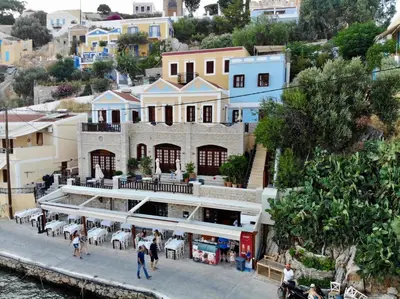 a building with people walking in front of it at Odyssia in Symi