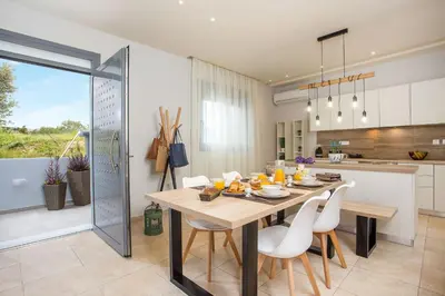 a kitchen and dining room with a table and chairs at The Sisters Villa in Kalithies