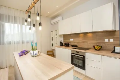 a kitchen with white cabinets and a wooden counter top at The Sisters Villa in Kalithies