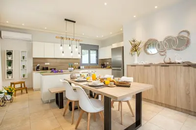 a kitchen and dining room with a table and chairs at The Sisters Villa in Kalithies