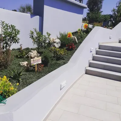 a set of stairs in a garden with flowers at The Sisters Villa in Kalithies