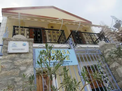 a house with a sign in front of it at Chryssa Rooms in Symi