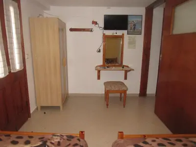 a living room with a mirror and a chair at Chryssa Rooms in Symi