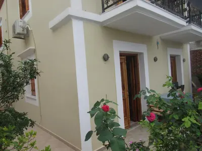 a house with a balcony and a plant at Chryssa Rooms in Symi