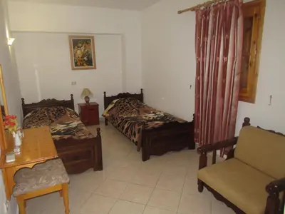 a bedroom with two beds and a couch and a chair at Chryssa Rooms in Symi