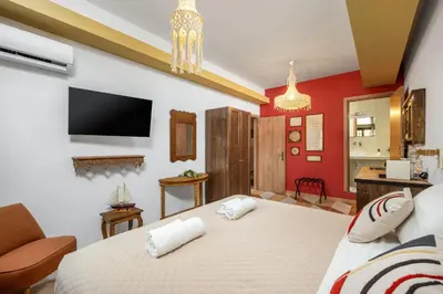 a bedroom with a bed and a tv on the wall at The Old Symi in Symi