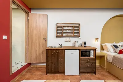 a small kitchen with a sink and a bed at The Old Symi in Symi