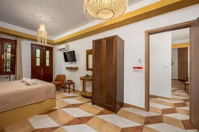 a hotel room with a bed and a living room at The Old Symi in Symi