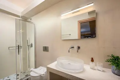 a bathroom with a sink and a shower and a mirror at The Old Symi in Symi