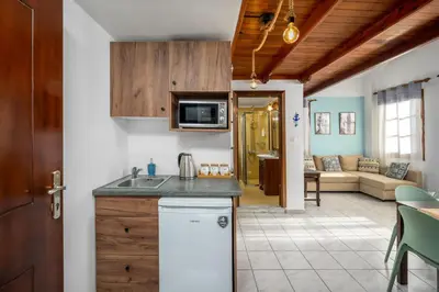 a kitchen with a counter top and a living room at The Old Symi in Symi