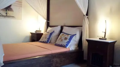 a bedroom with a bed with a canopy and pillows at Petrino in Rhodes Town