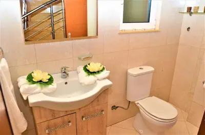 a bathroom with a sink and a toilet and a mirror at Mediterranean Luxury Villa in Ialyssos