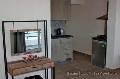 a kitchen with a counter with a mirror and a sink at Budget Studios Haraki in Haraki