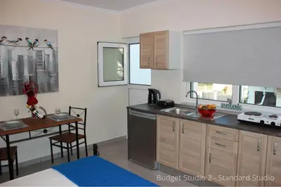 a kitchen with a sink and a table in a room at Budget Studios Haraki in Haraki