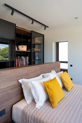 a bedroom with a bed with yellow and white pillows at Momentum Villas in Ialyssos