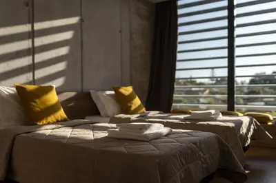 two beds in a room with yellow pillows at Momentum Villas in Ialyssos