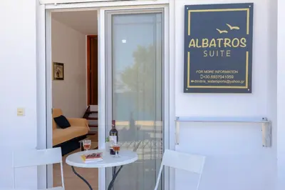 a door to a room with a table and a sign at ALBATROS SUITE STEGNA BEACH in Archangelos