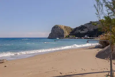 a beach with people swimming in the ocean at ALBATROS SUITE STEGNA BEACH in Archangelos