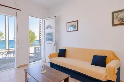 a living room with a couch and a table at ALBATROS SUITE STEGNA BEACH in Archangelos