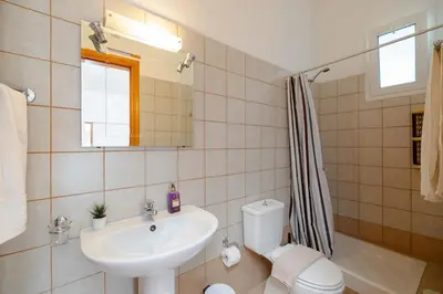 a bathroom with a sink and a toilet and a mirror at ALBATROS SUITE STEGNA BEACH in Archangelos