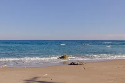 a beach with two rocks in the water at ALBATROS SUITE STEGNA BEACH in Archangelos