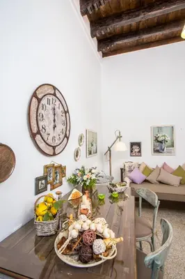 a dining room with a table with a clock on the wall at La casa di Anna in Rhodes Town