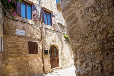 an alley in an old stone building with a wooden door at La casa di Anna in Rhodes Town