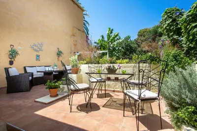 a patio with chairs and a table in a garden at La casa di Anna in Rhodes Town