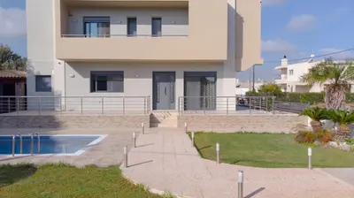 a house with a swimming pool in front of it at Villa Stamatina in Pastida