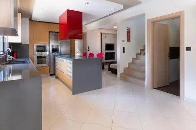 a kitchen with a large island with a red cabinet at Villa Stamatina in Pastida