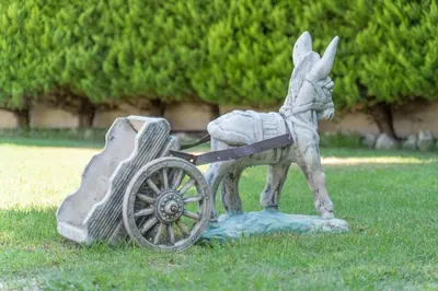 a statue of a donkey pulling a cart in the grass at Villa Stamatina in Pastida