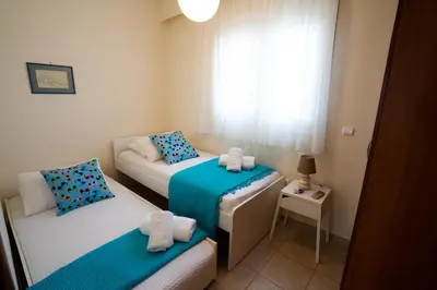 a small room with two beds and a window at Alkion Villa in Gennadi