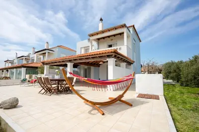 a hammock on a patio in front of a house at Alkion Villa in Gennadi