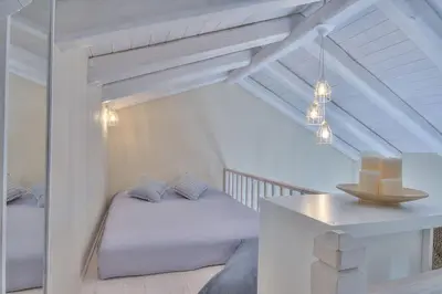a white bedroom with a bed and a table at Rhodian Gaea Villa in Theologos