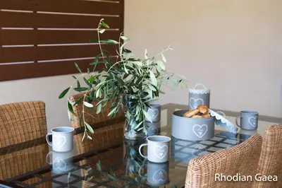 a glass table with a potted plant and cups on it at Rhodian Gaea Villa in Theologos