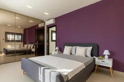 a purple bedroom with a bed and a bathroom at La Luna Villa in Rhodes Town