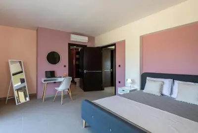 a bedroom with a bed and a desk in a room at La Luna Villa in Rhodes Town