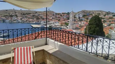 a balcony with two chairs and a view of a city at Rosalia Apartments in Halki