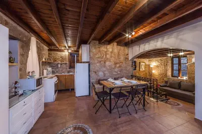 a kitchen and living room with a table and a refrigerator at Rosalia Apartments in Halki