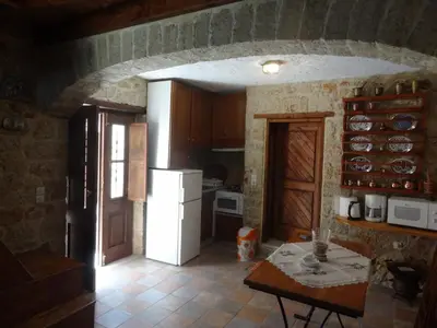 a kitchen with a table and a white refrigerator at Rosalia Apartments in Halki