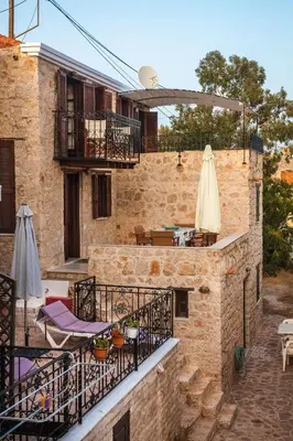 an outdoor patio with tables and umbrellas on a building at Rosalia Apartments in Halki