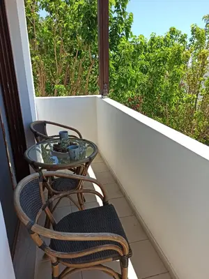 two chairs and a glass table on a balcony at Blue Harmony Villas in Kiotari
